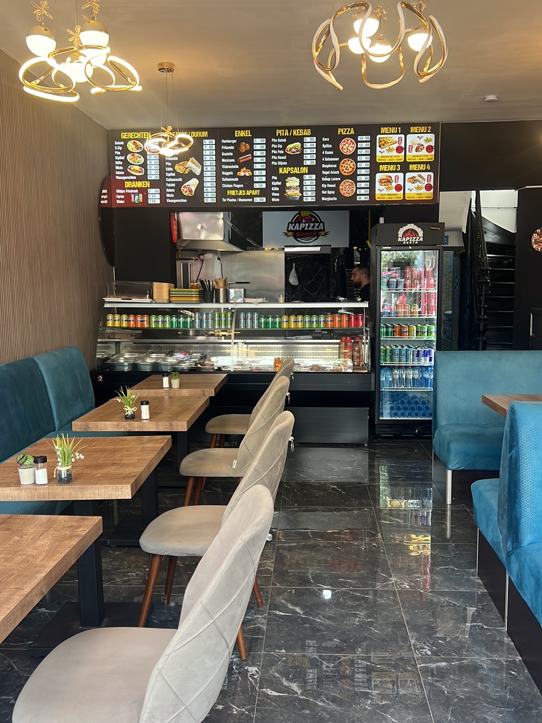 Interieur van Kapizza Snack in Mechelen met menubord en zitplaatsen